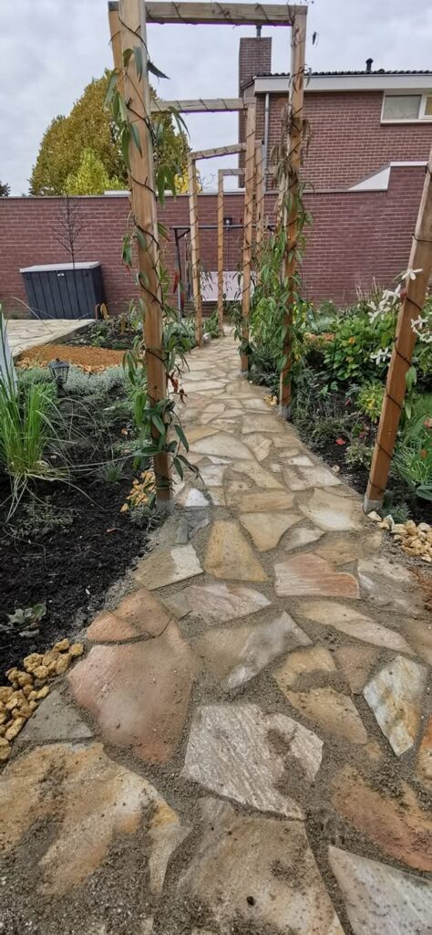 Achtertuin met organisch gelegde flagstone paden en terras, aangelegd door Tuinproject Limburg