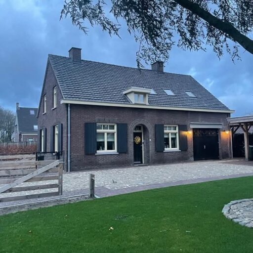 Voortuin met decoratieve bestrating en symmetrische beplanting maaskeien natuursteen